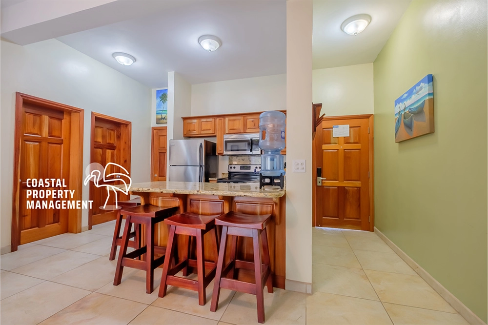 Modern kitchen with wooden cabinets and stools.