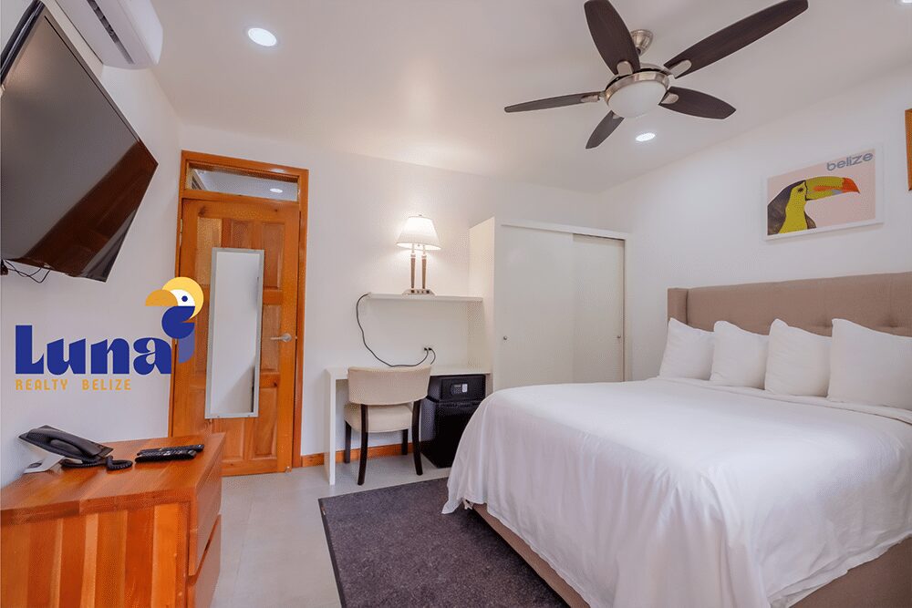 Modern hotel room with bed and desk.