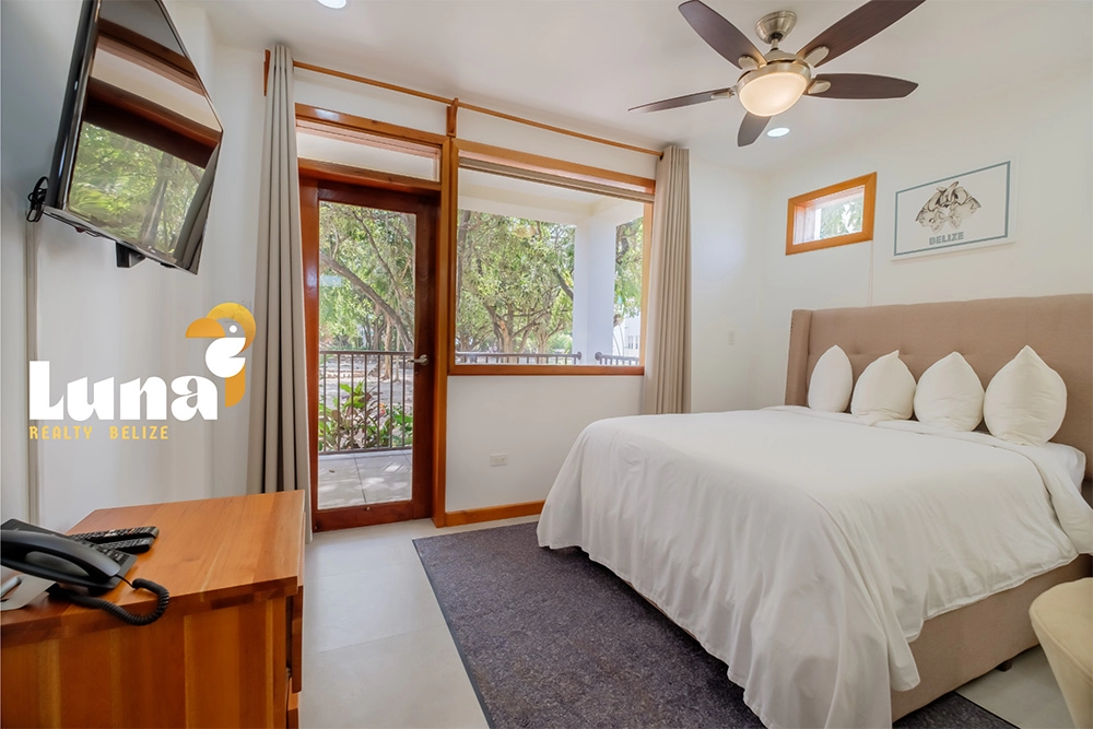 Bright hotel room with bed and balcony.