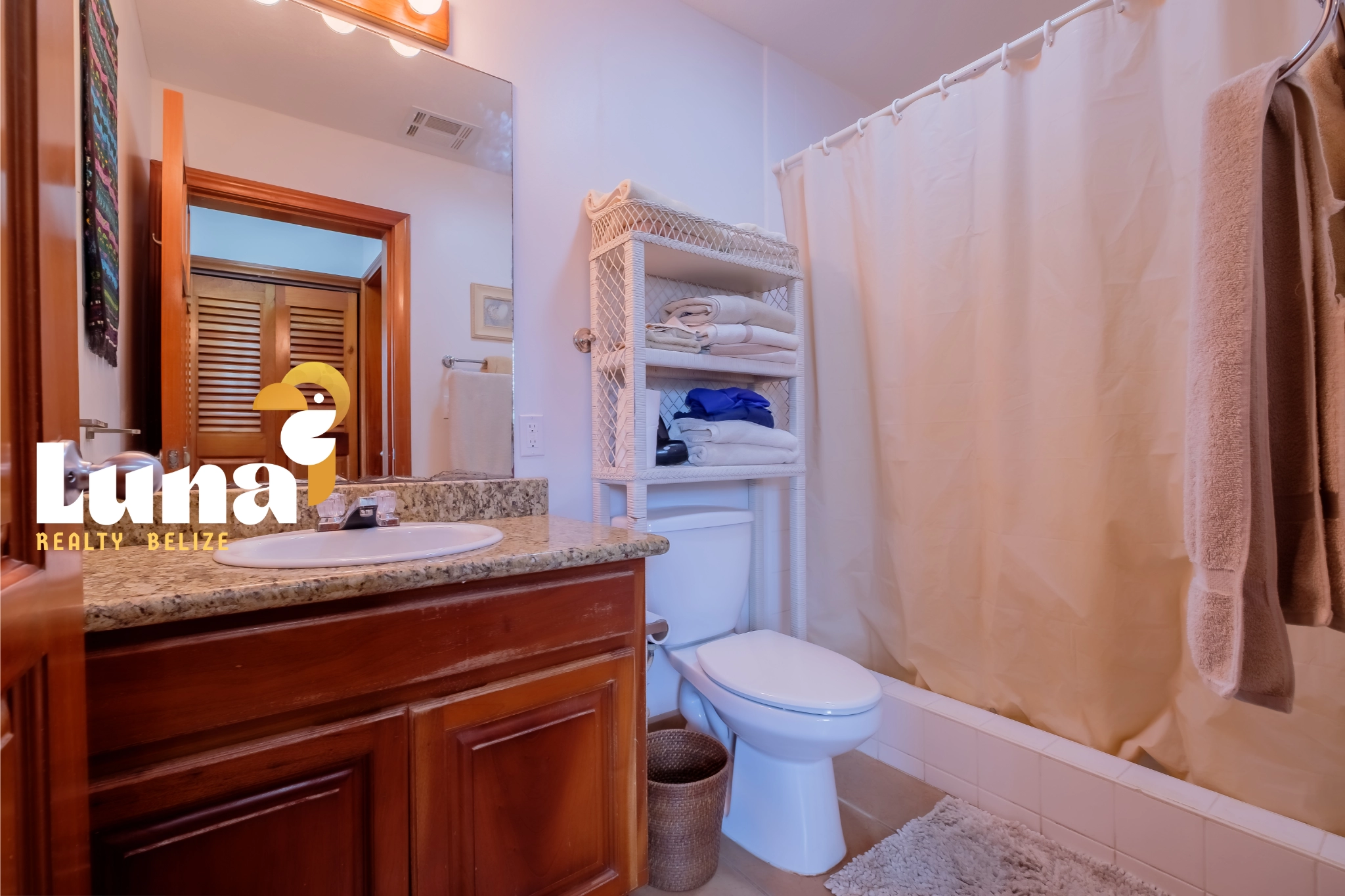 Bathroom with wooden cabinets and shower curtain.
