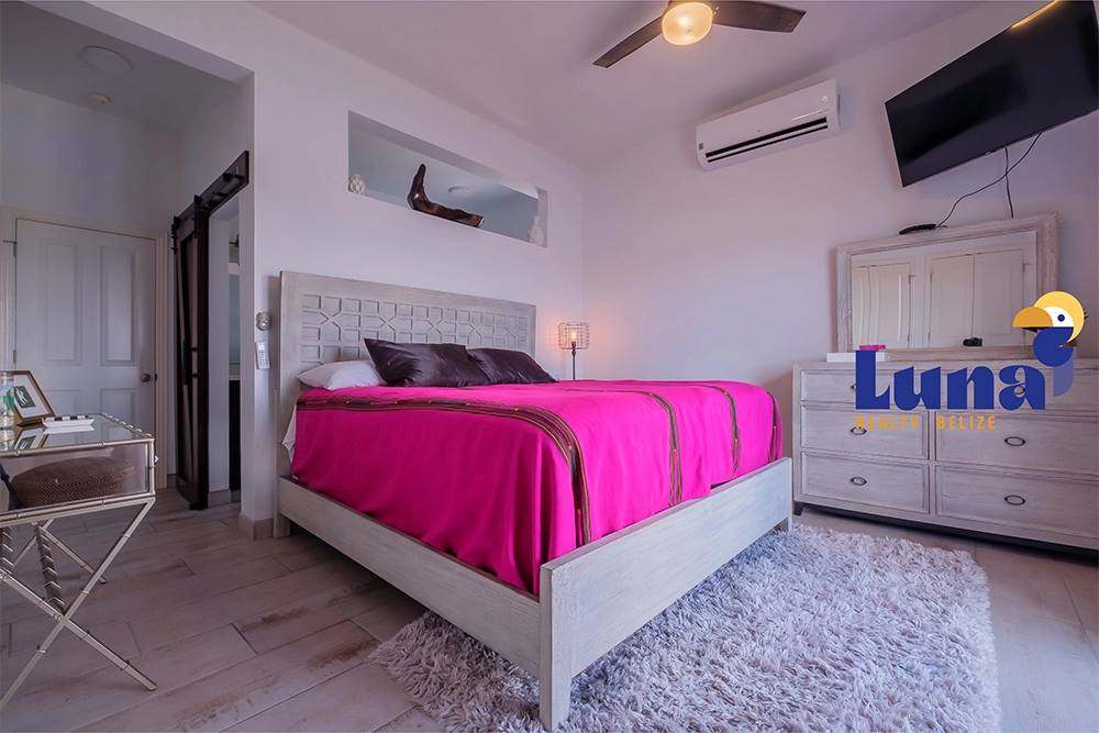 Bedroom with pink bedding and modern decor.