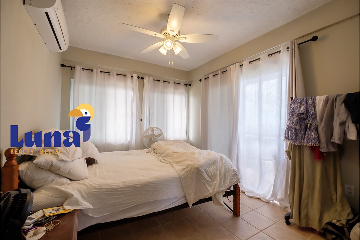 Cozy bedroom with fan and natural light.