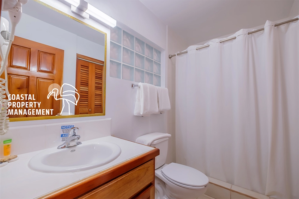 Bathroom with sink, toilet, and shower curtain.