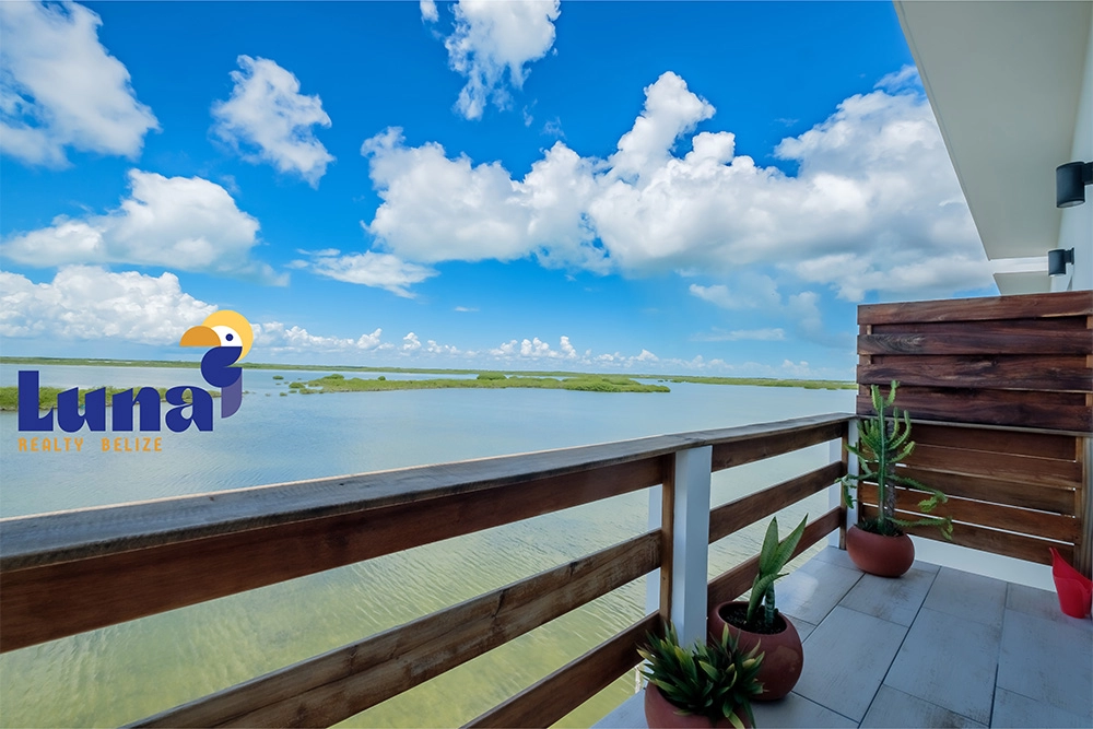 Balcony overlooking serene lake and cloudy sky.