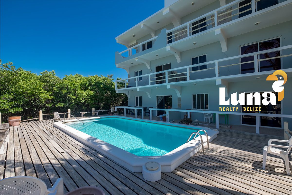 Apartment complex with pool and wooden deck.