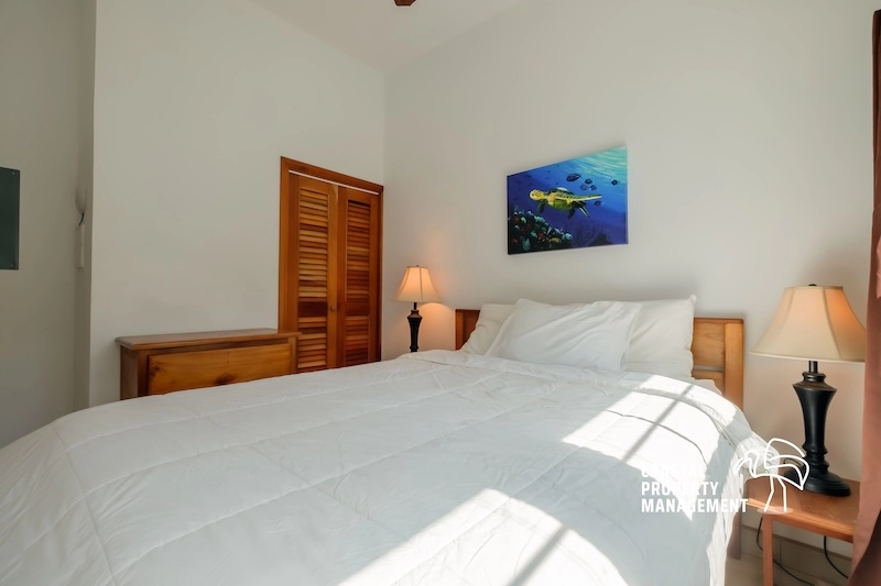 Cozy bedroom with white bedding and lamps.