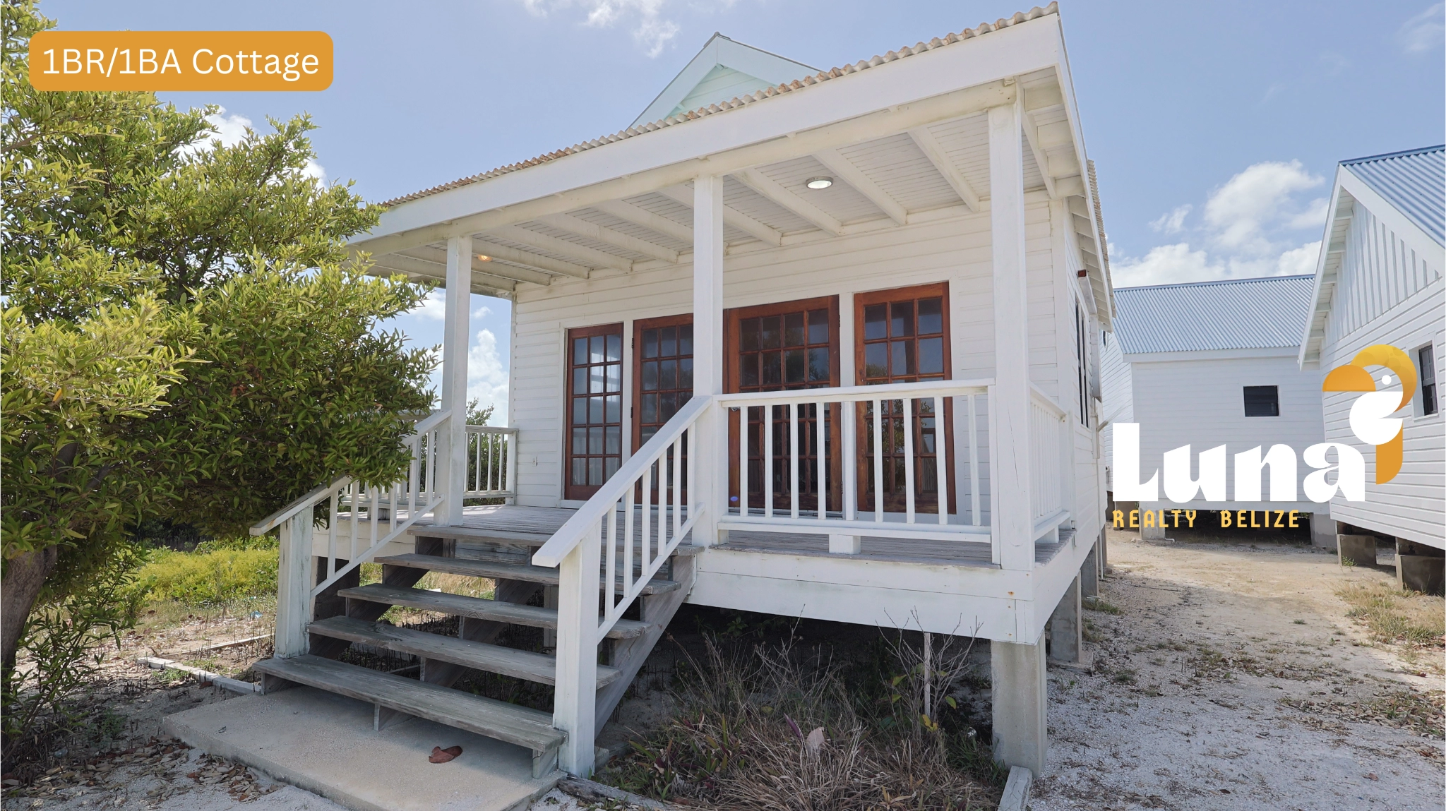 White beachfront cottage with wooden porch steps.