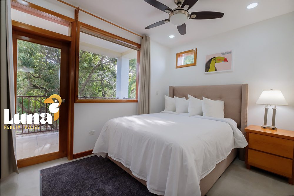 Modern bedroom with large window and bed.
