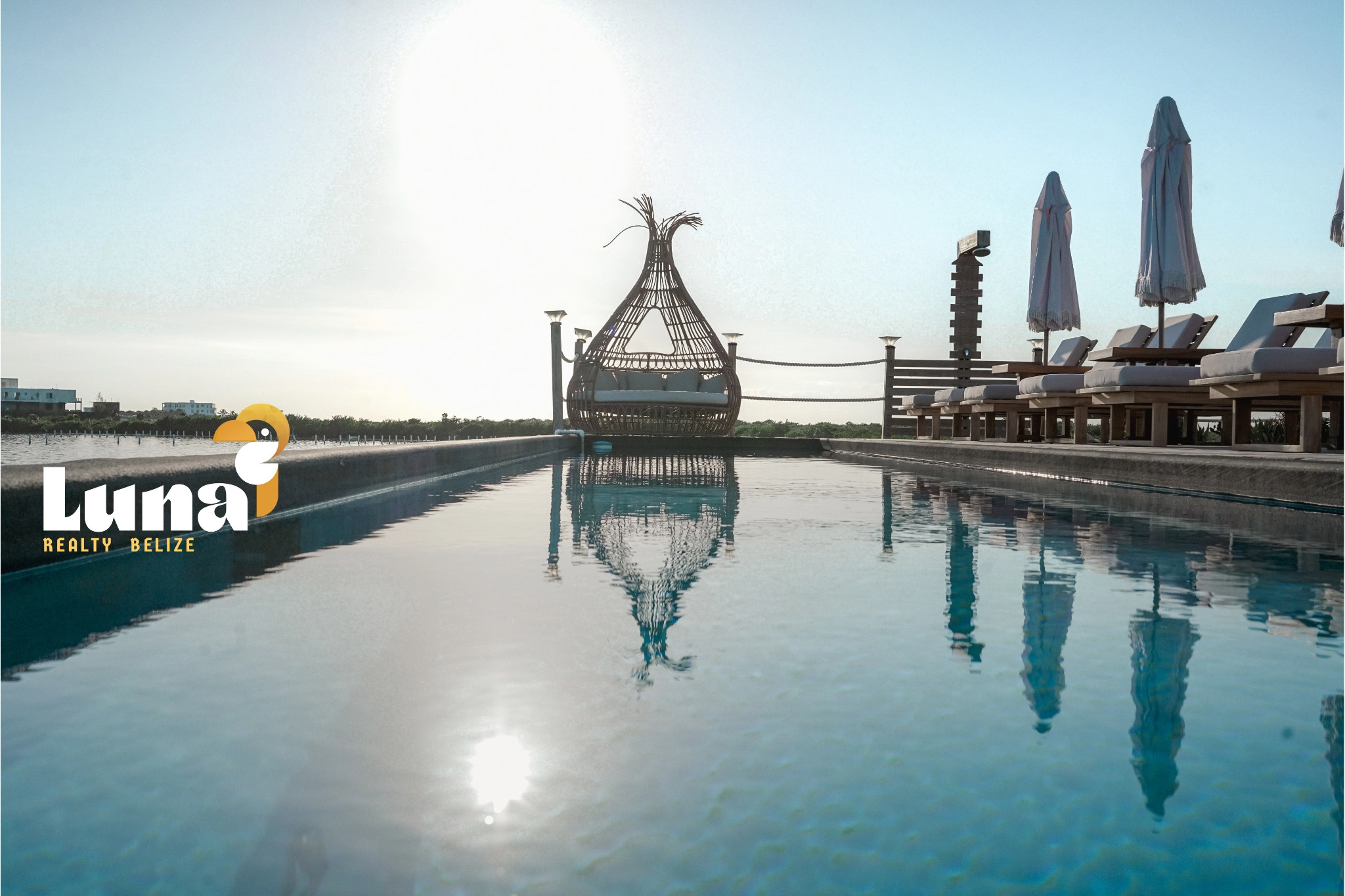 Rooftop pool with lounge chairs and umbrellas.