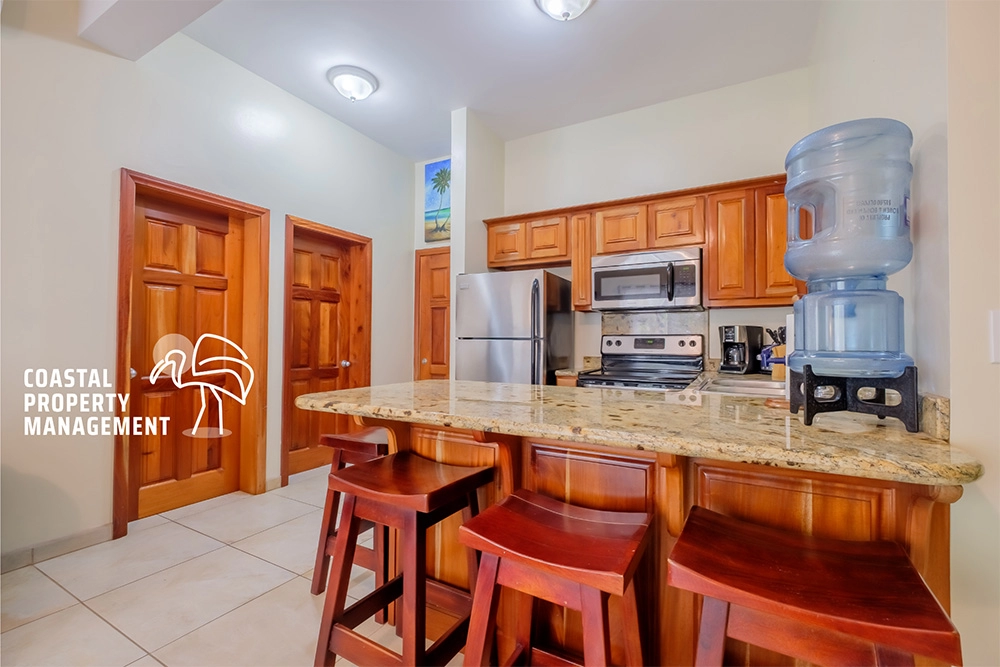 Cozy kitchen with wooden cabinetry and stools.