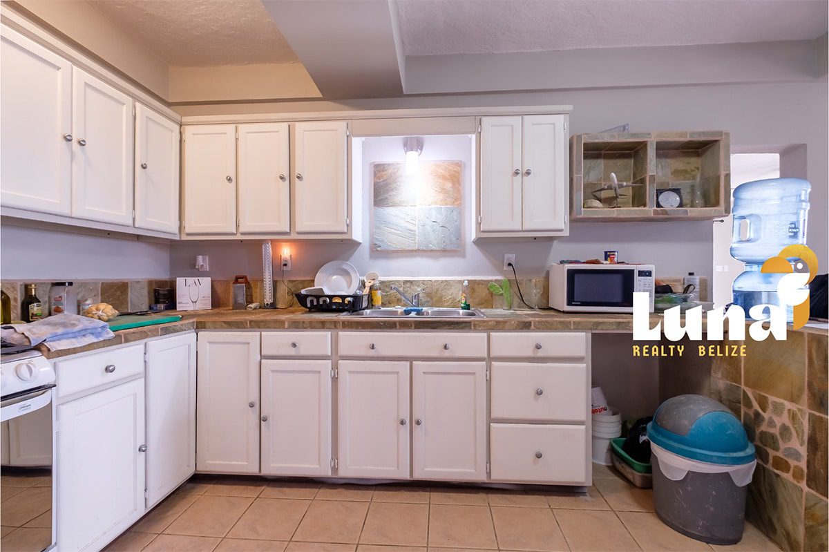 Modern kitchen with white cabinets and appliances.