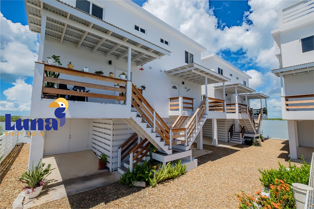 White beachfront houses with wooden balconies.
