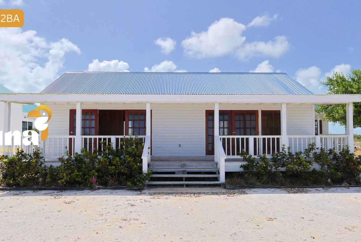 White cottage with a front porch.