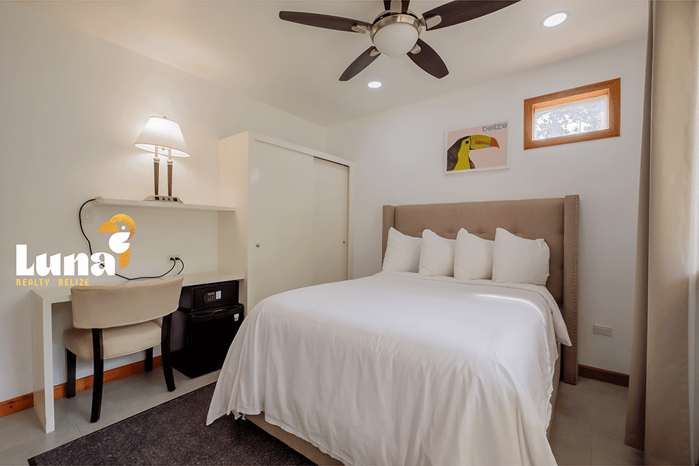 Cozy bedroom with bed and desk area.