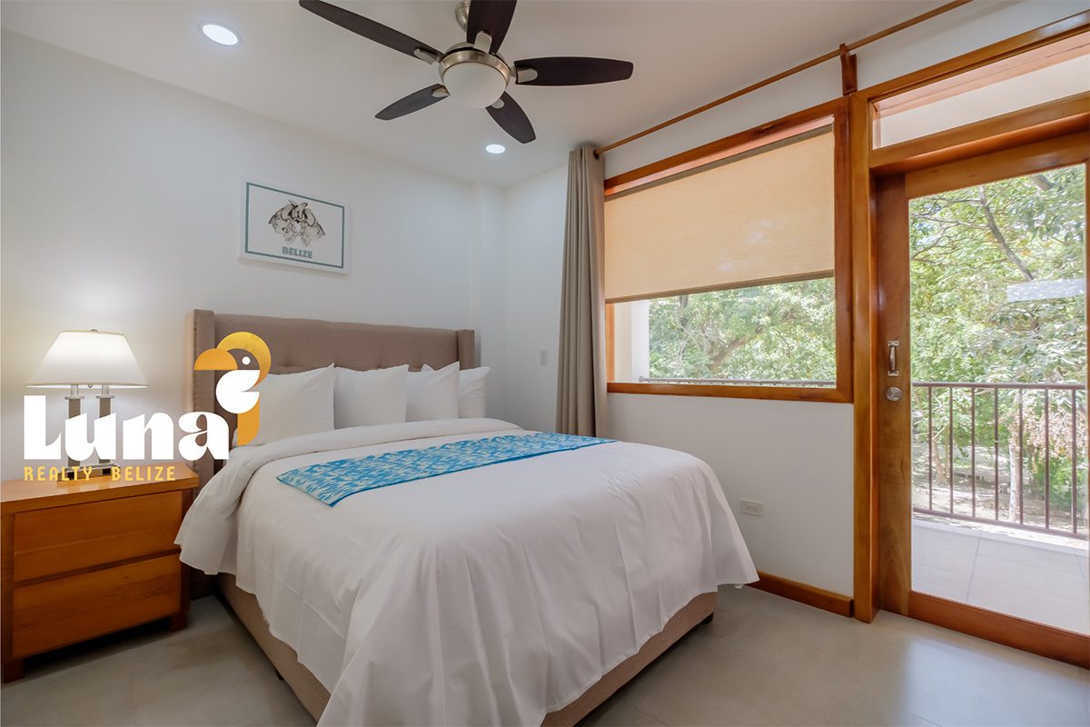 Bedroom with bed, lamp, and balcony view.