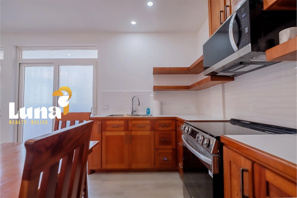 Modern kitchen with wooden cabinets and appliances.