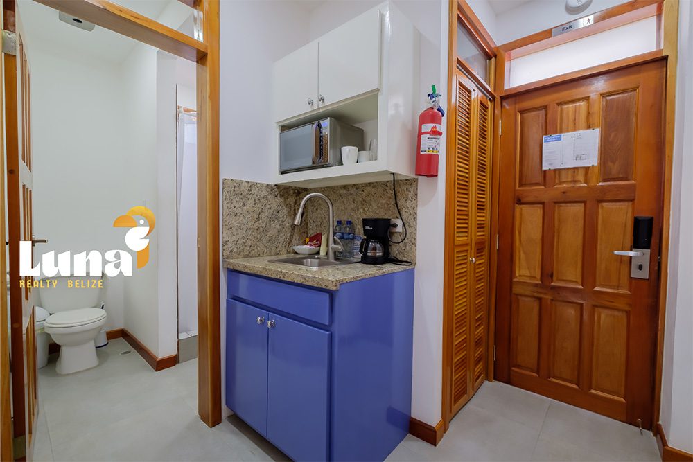 Small kitchenette and bathroom in hotel room.