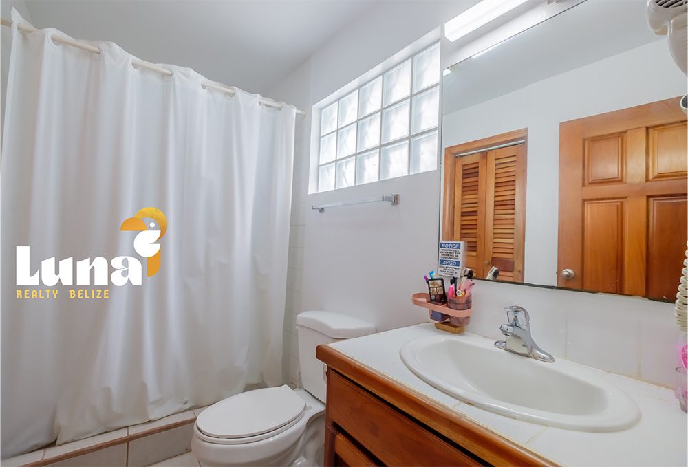 Bathroom with shower curtain and sink.