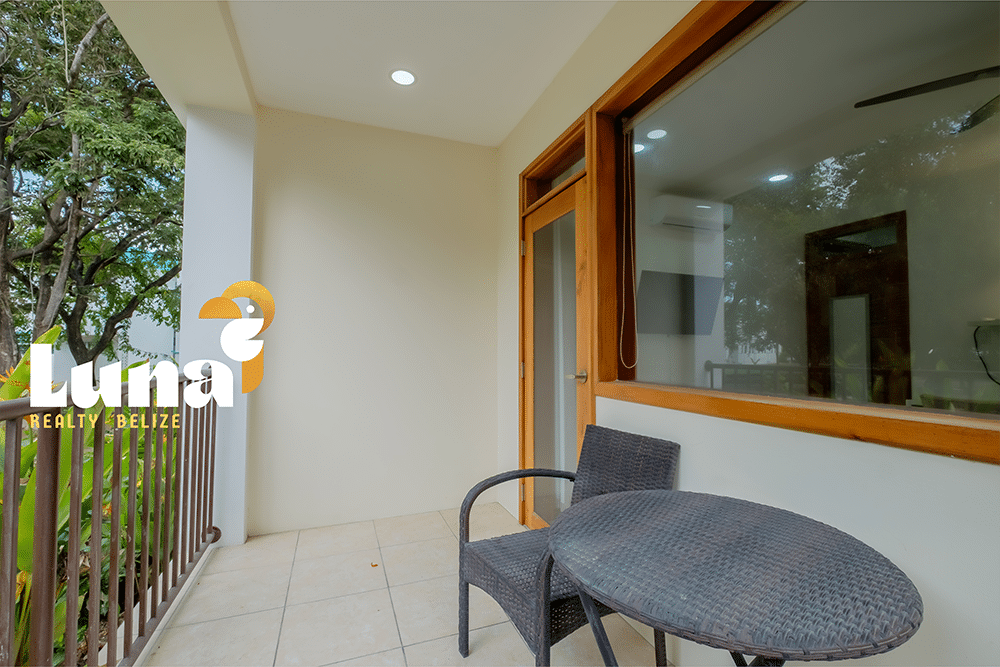 Outdoor balcony with chairs and table.