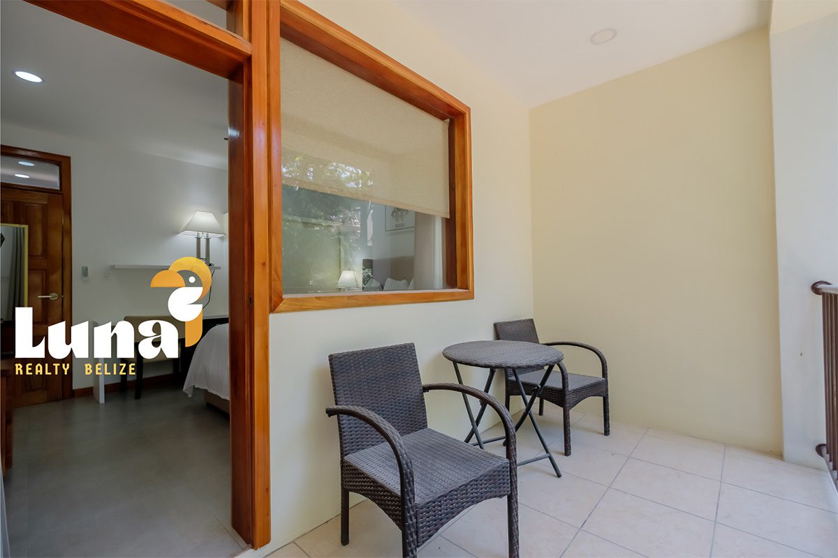 Patio with chairs and table, wooden window.