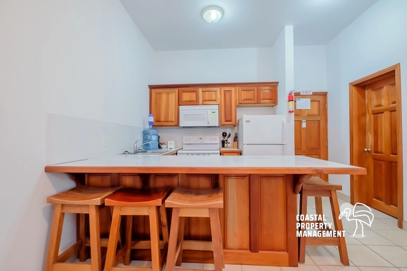 Kitchen with wooden cabinets and stools.