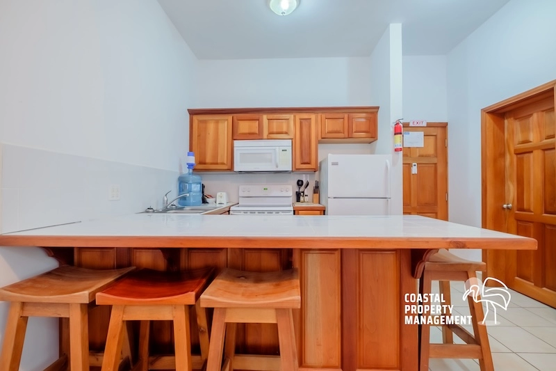 Kitchen with wooden cabinets and bar stools.