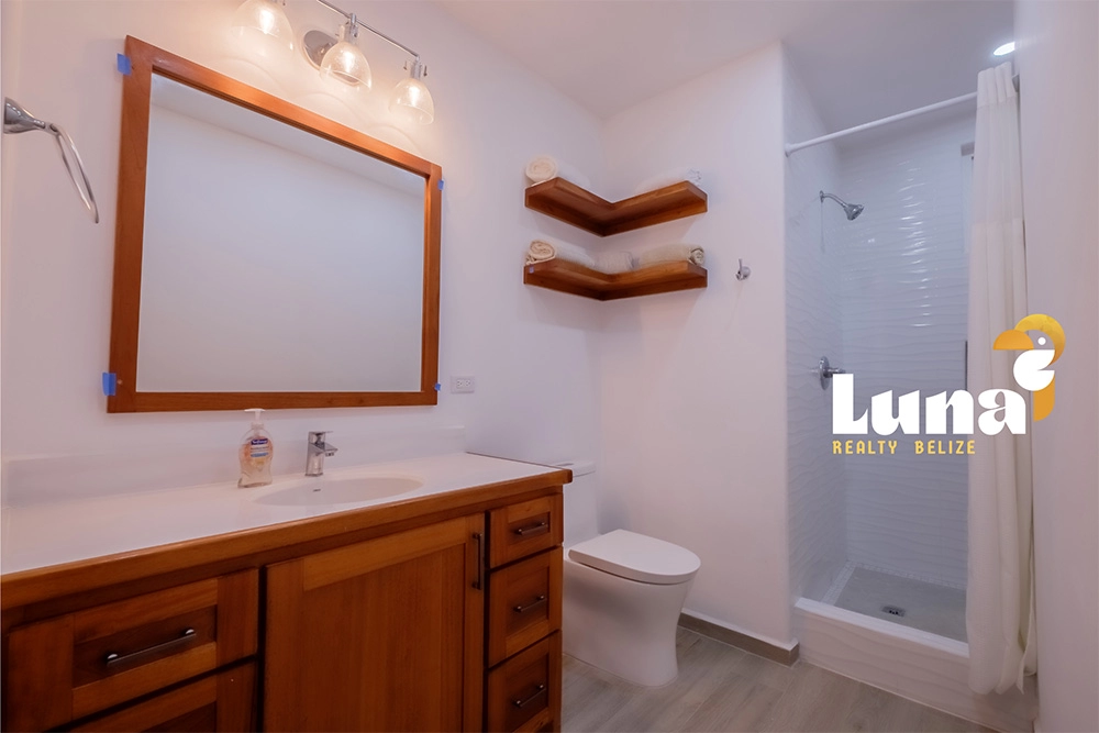 Bathroom with wooden cabinets and shower.