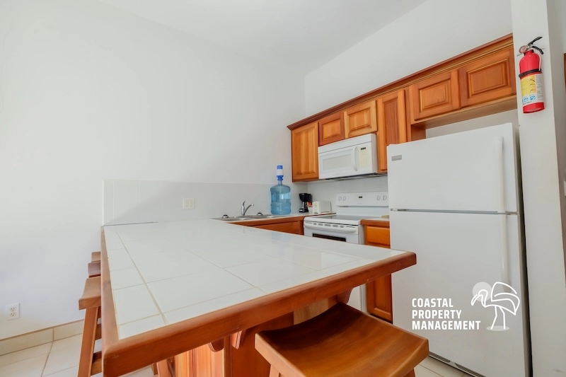 Kitchen with wooden cabinets and white appliances.