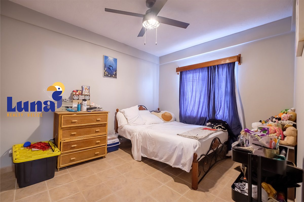 Bedroom with bed, dresser, and ceiling fan.