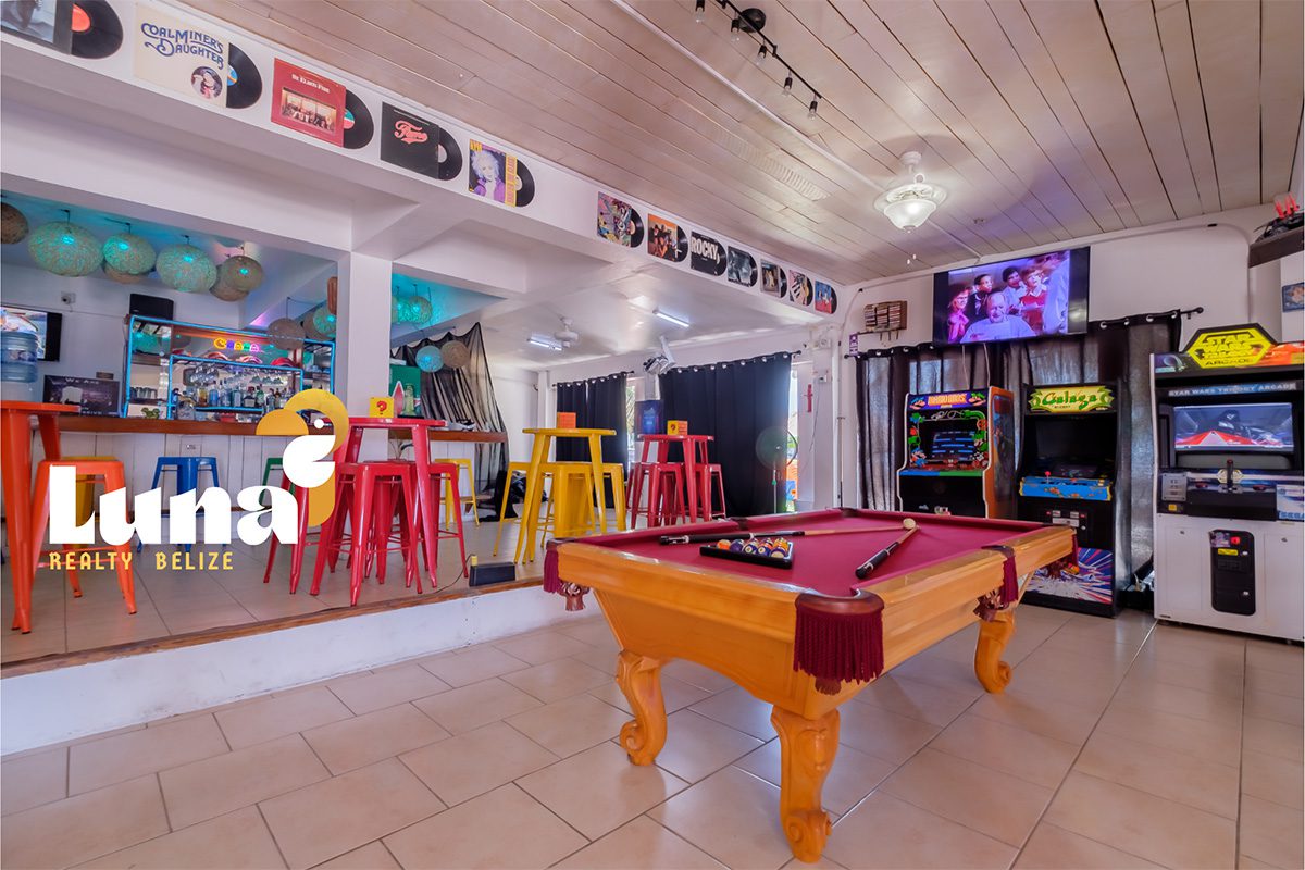 Pool table in colorful arcade bar setting.