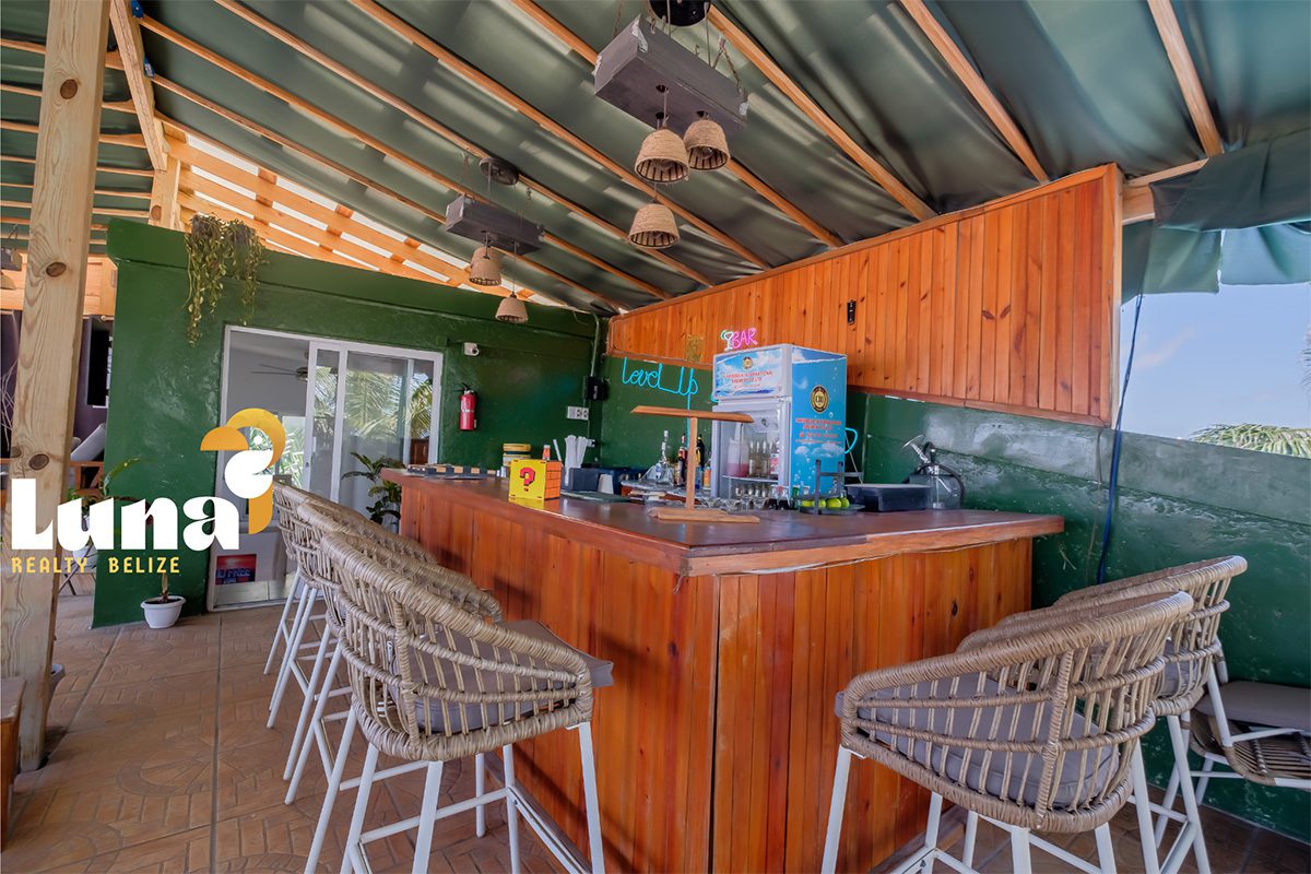 Outdoor bar with wicker stools and counter.