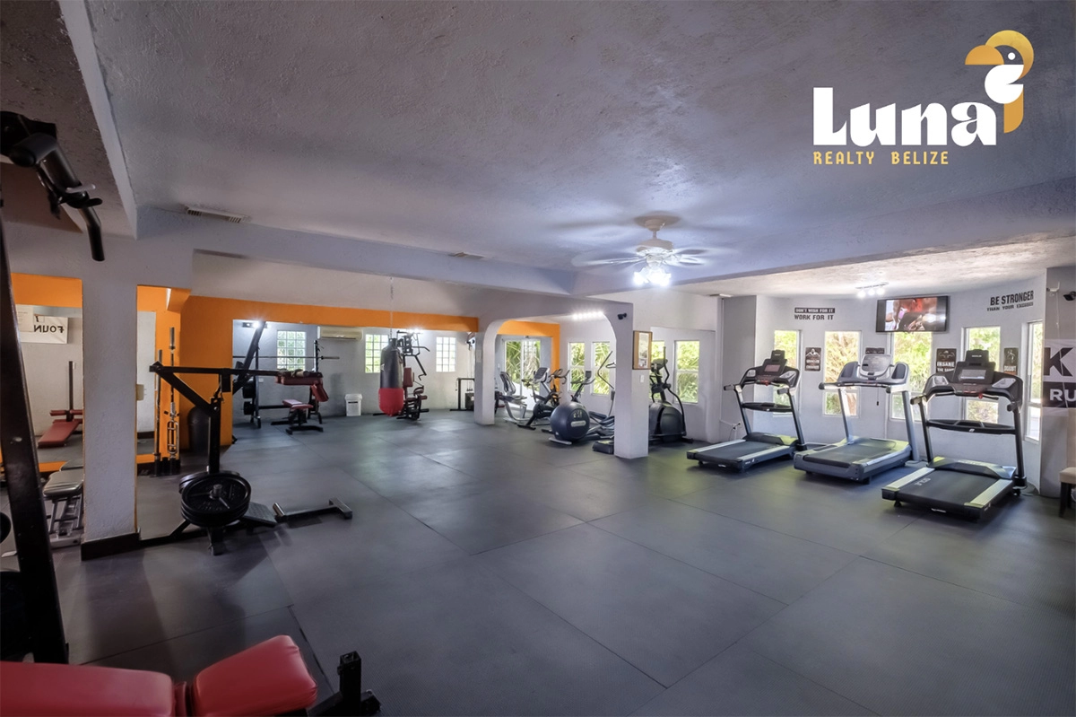 Modern gym with treadmills and weight machines.
