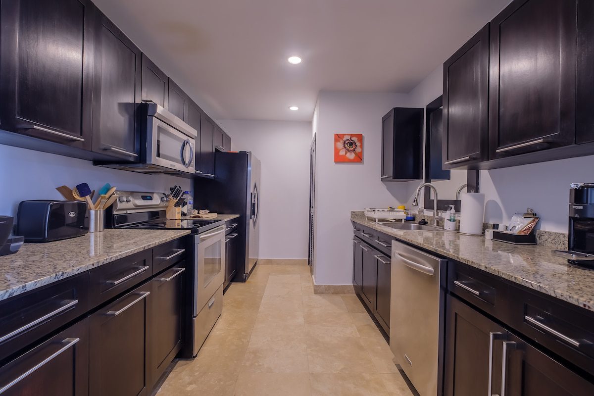 Modern kitchen with dark cabinets and appliances.