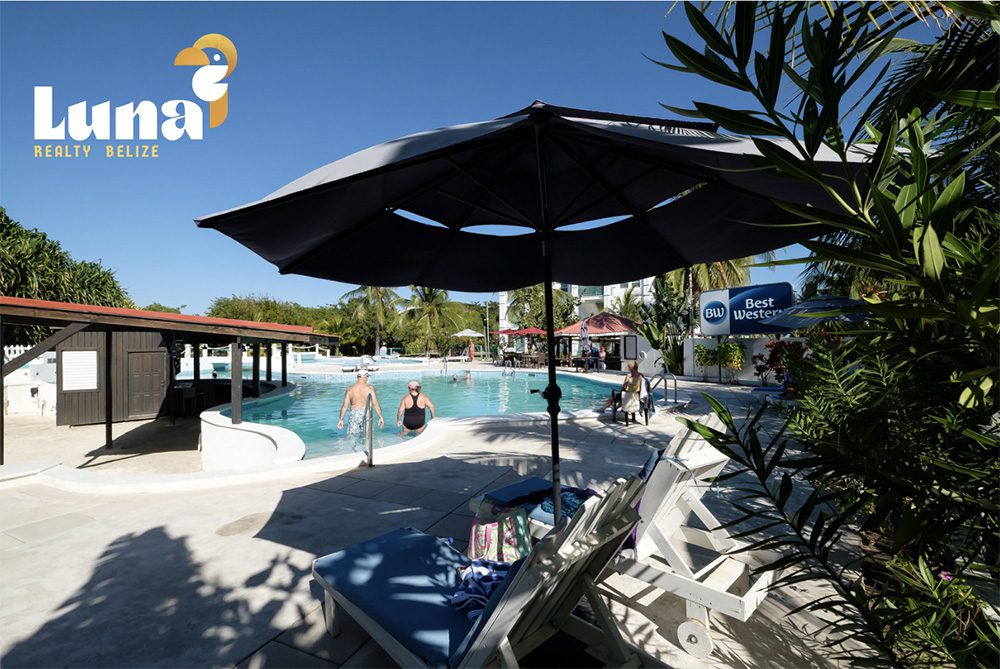 Outdoor pool area with lounge chairs and umbrellas.