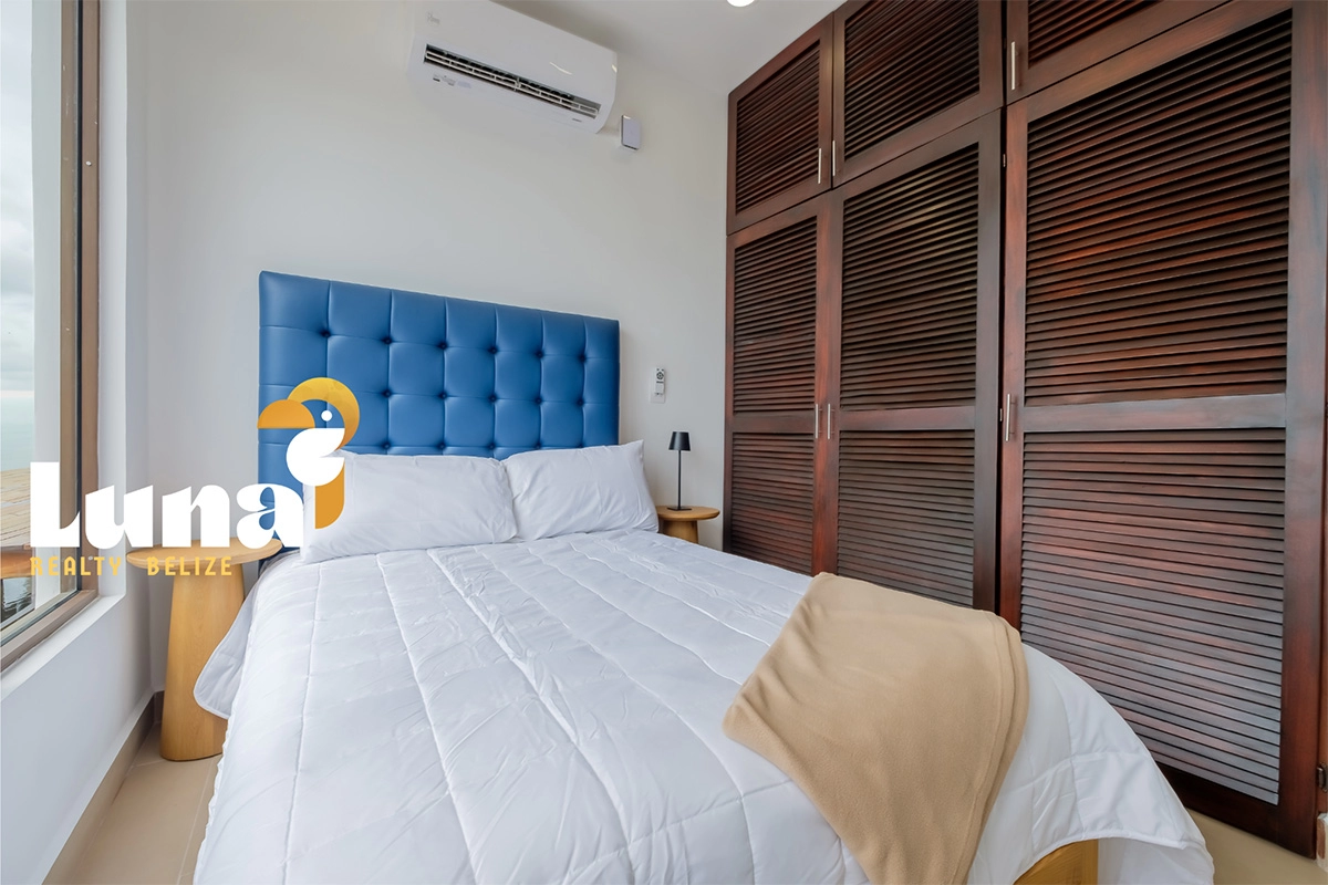 Modern bedroom with blue headboard and closet.