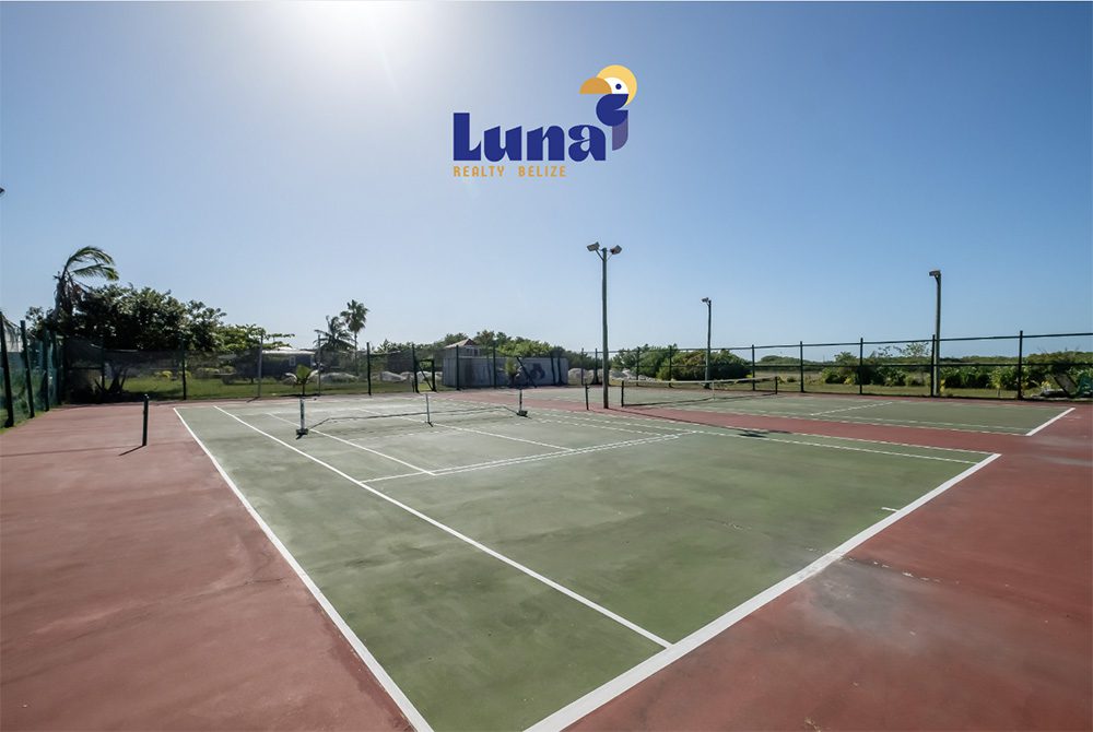Outdoor tennis court under clear blue sky.
