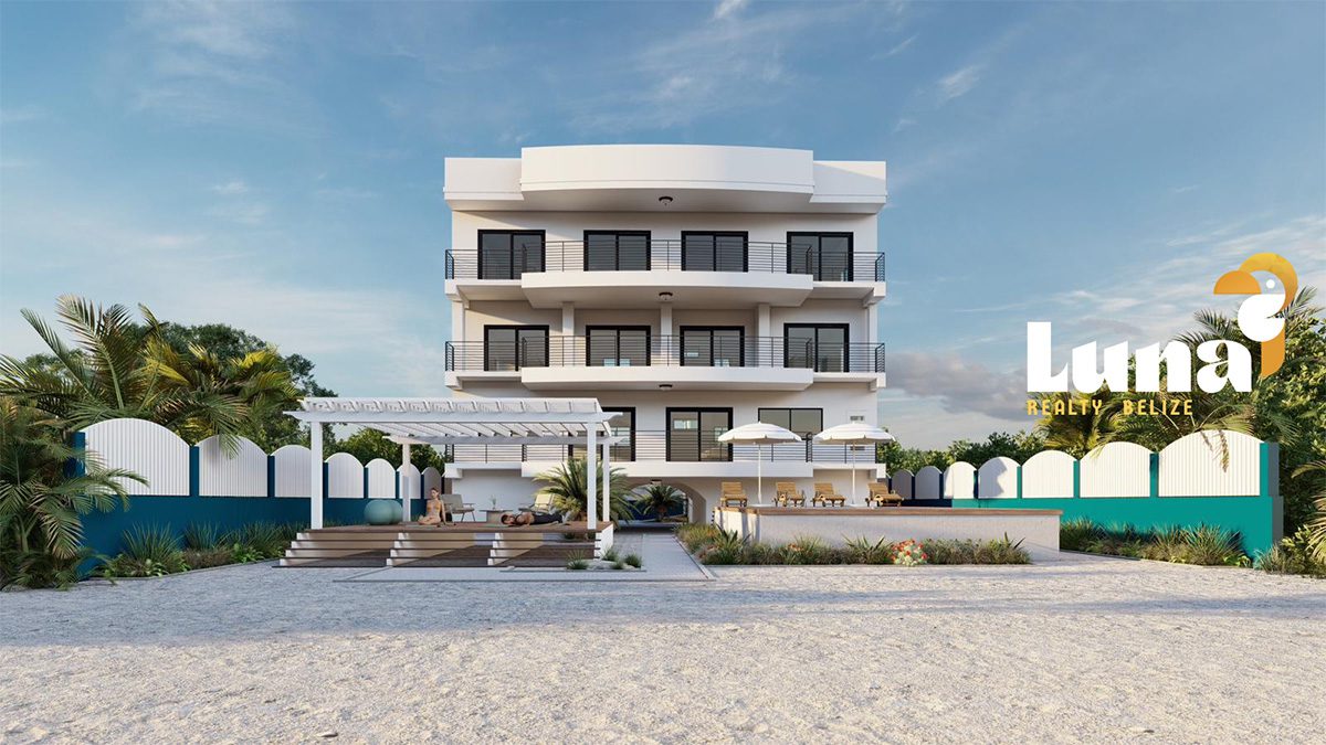 Beachfront building with palm trees and umbrellas.
