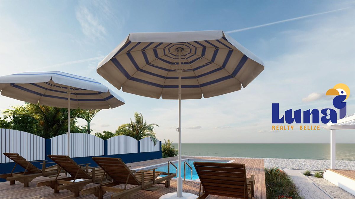 Poolside deck chairs and umbrellas by ocean.