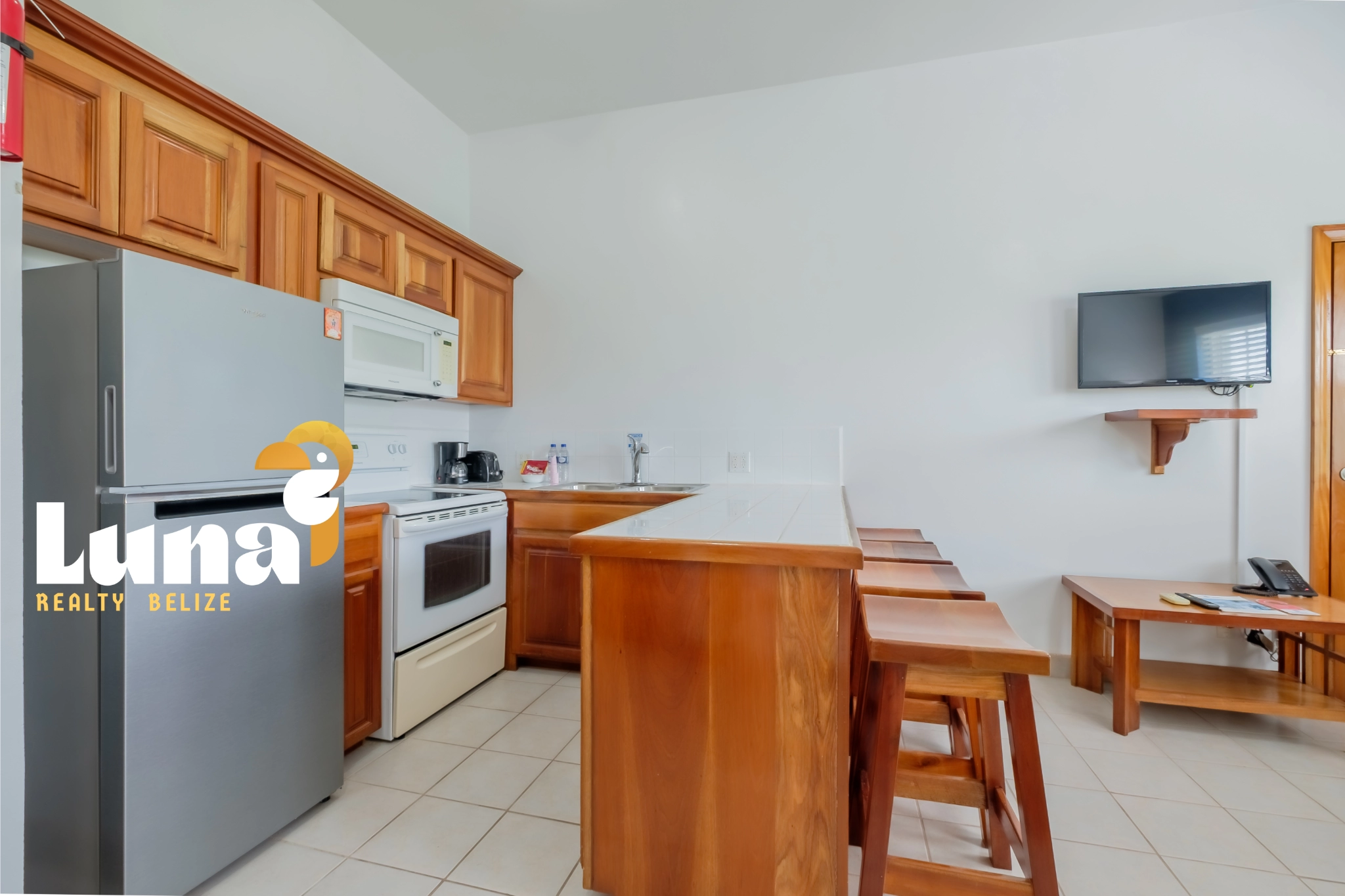 Kitchen with wooden cabinets and bar stools.